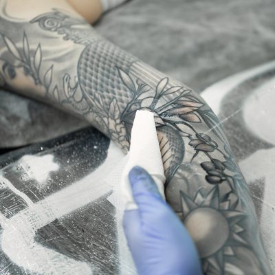 Tattoo artist makes a tattoo on a young girl's hand